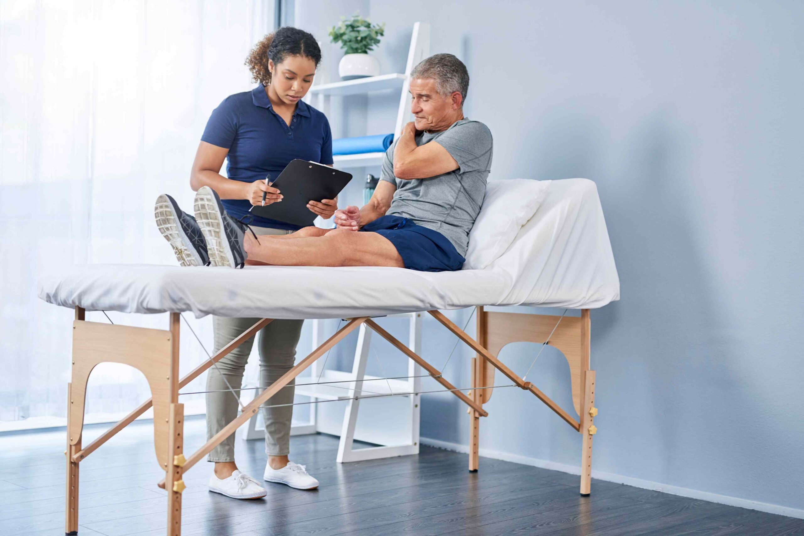 Physiotherapeutin behandelt Patienten in einer Praxis