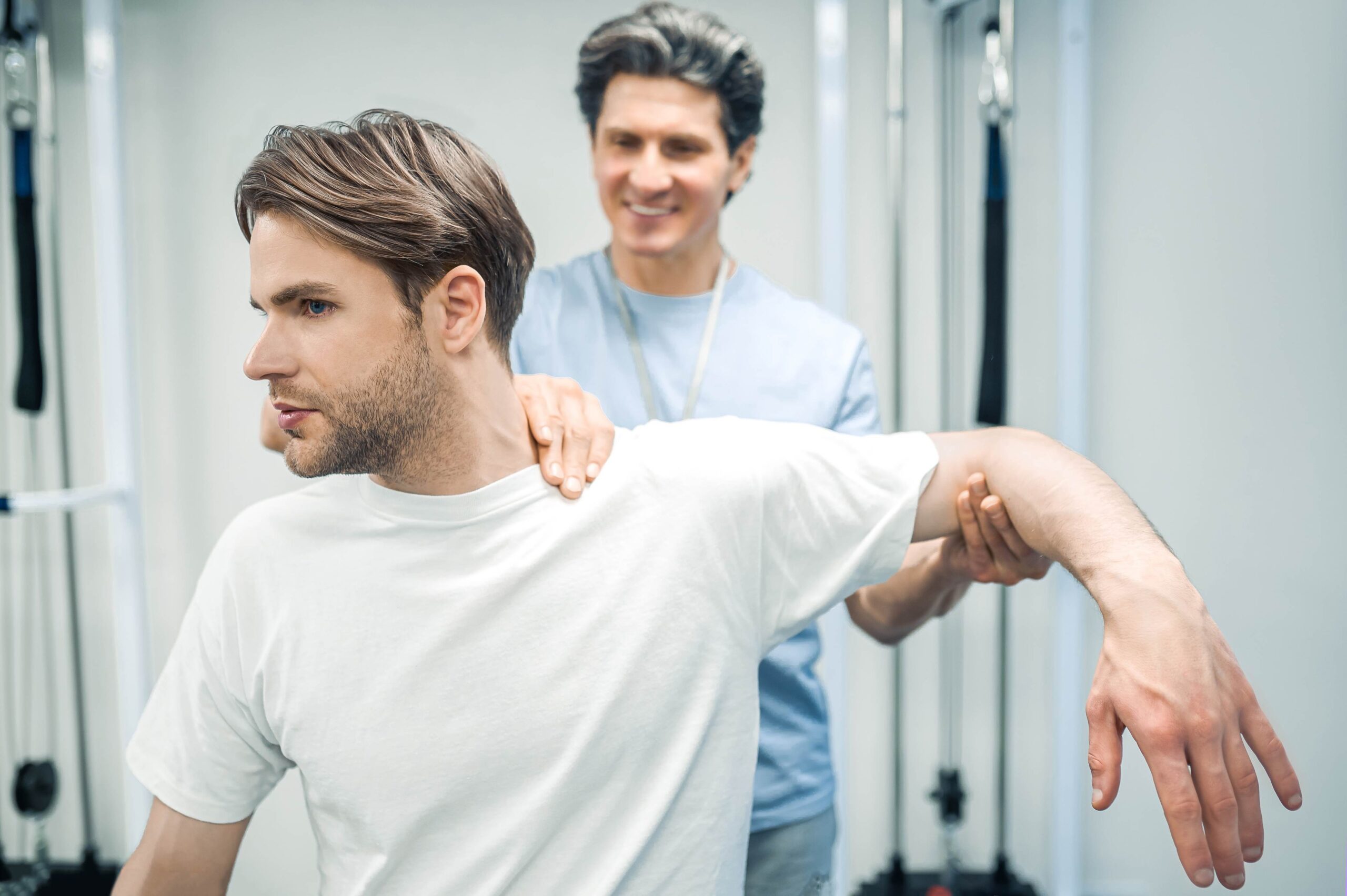 Physiotherapeut begleitet Patient bei Übungen in einer Reha-Situation (Symbolbild)